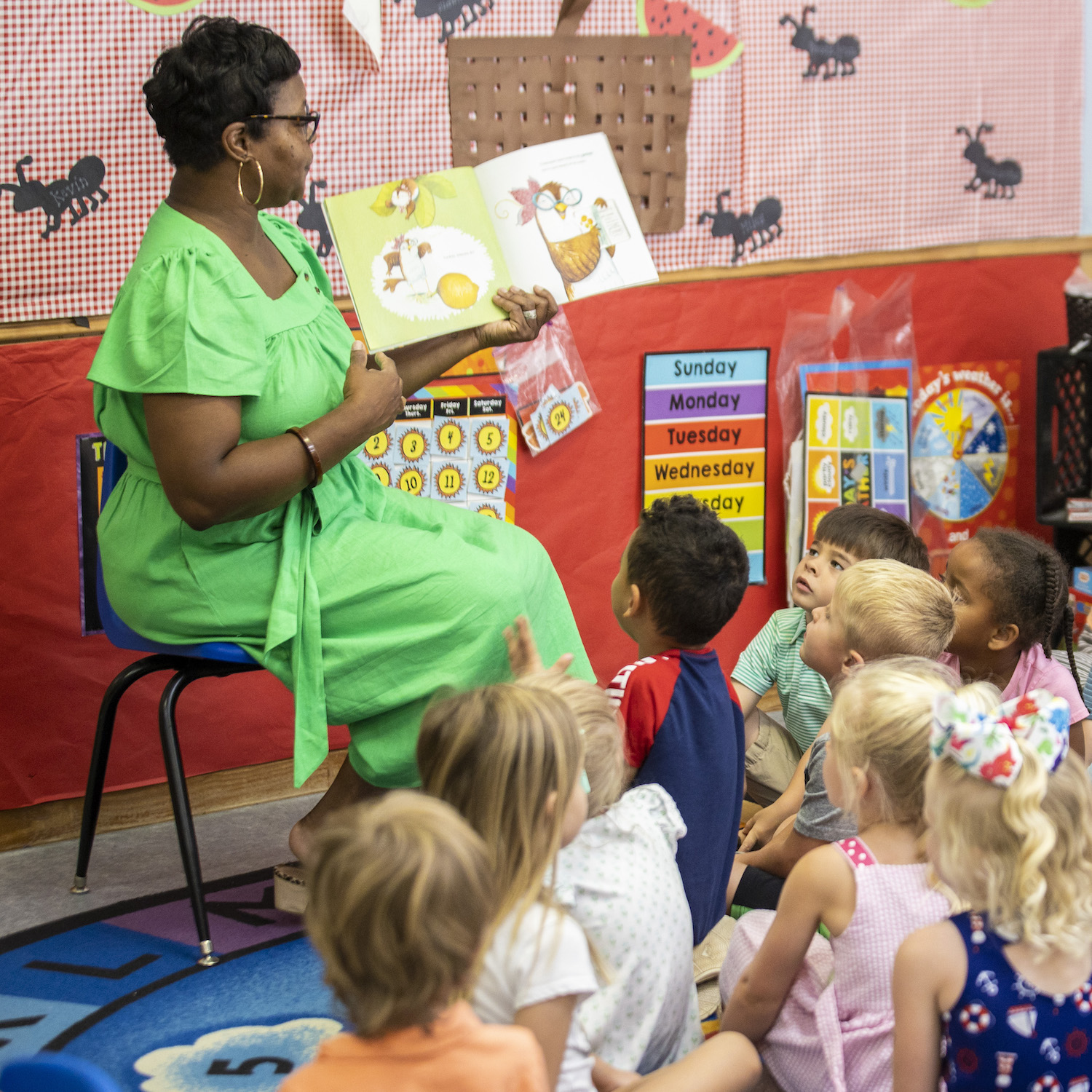Instructor reading book to children seated on the floor