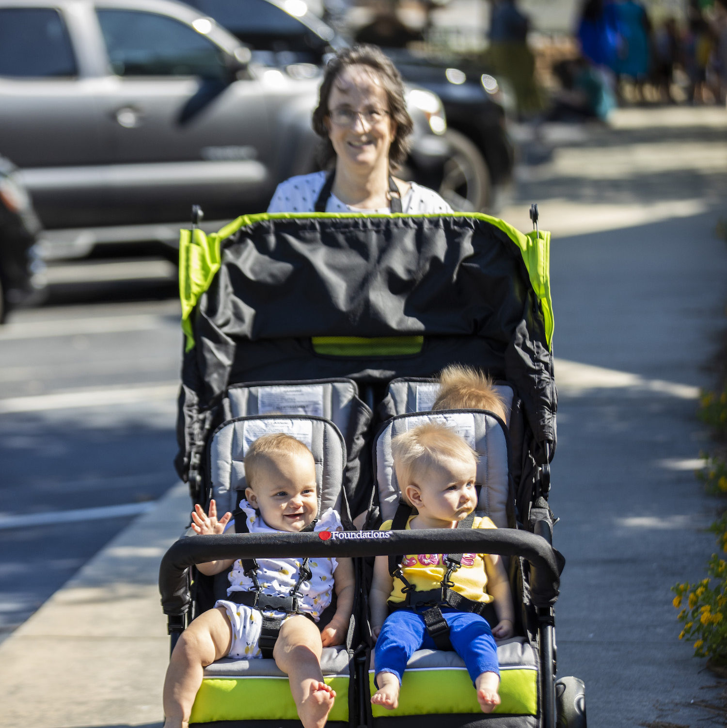 Parent pushing two children in double stroller